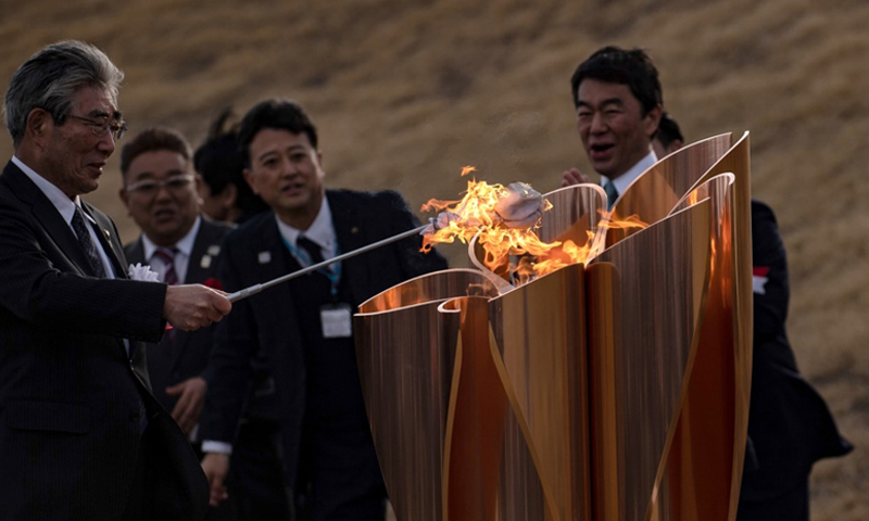 Olympic flame gets muted welcome in Japan as Games doubts grow