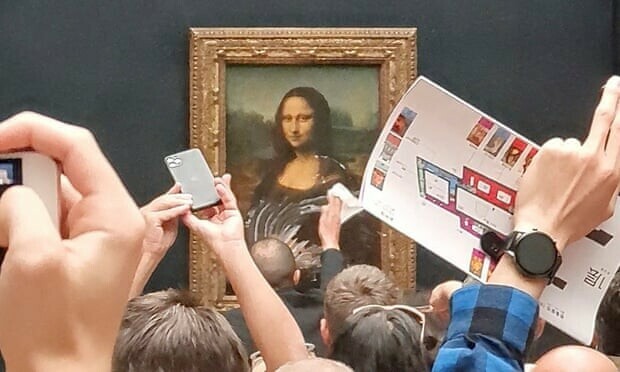 Mona Lisa left unharmed but smeared in cream in climate protest stunt