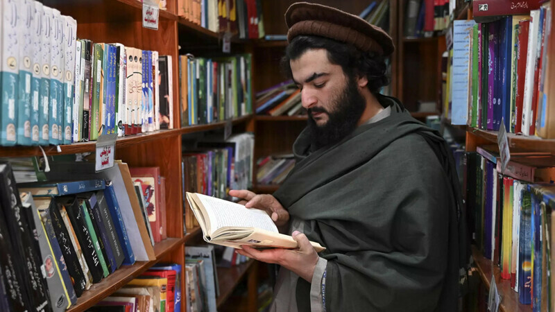 Arms dealer Hakimullah Afridi reads a book at the library – AFP