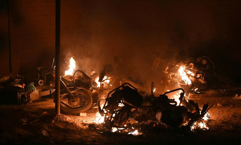 Vehicles are on fire after a clash between police and supporters of former Pakistan prime minister Imran Khan near Khan’s residence, in Lahore on March 15, 2023. - Supporters of Khan clashed repeatedly with police overnight as he remained holed up in his Lahore residence early on March 15, defying attempts to arrest him – AFP