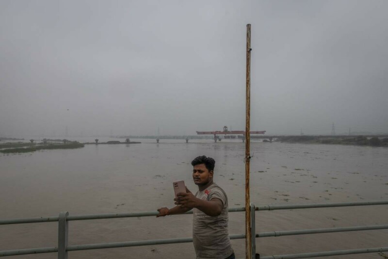  A man takes a selfie as he stands on a bridge over the overflowing river Yamuna after heavy monsoon rains, in New Delhi, India, July 13, 2023. Photo via Reuters. 