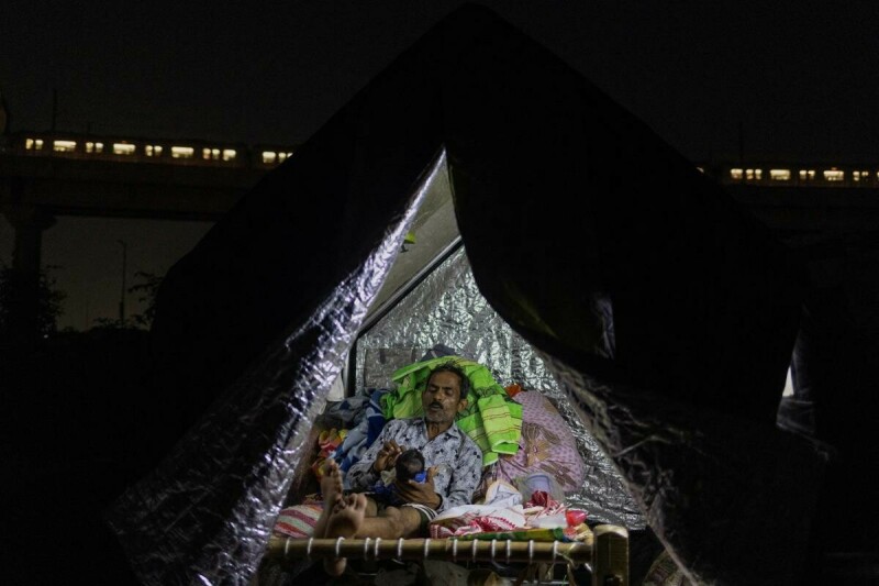  Guddu, 40, plays with his 21-day-old daughter, Rinki, in a makeshift shelter on a roadside, after being displaced by the rising water level of river Yamuna after heavy monsoon rains in New Delhi, India, July 12, 2023. Photo via Reuters. 