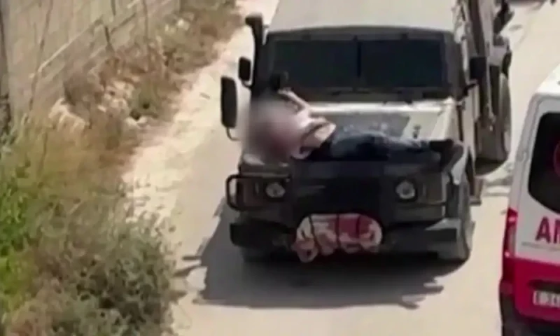 Israeli forces strap wounded Palestinian to jeep during raid