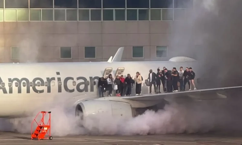 Passengers evacuate as American Airlines plane catches fire at Denver airport gate