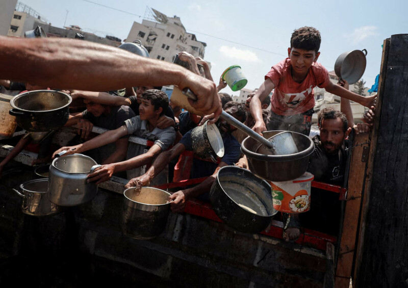 غزہ شہر میں بھوک کے بحران کے درمیان فلسطینی ایک خیراتی باورچی خانے سے کھانا لینے کے لیے جمع ہیں(تصویر بذریعہ رائٹرز)