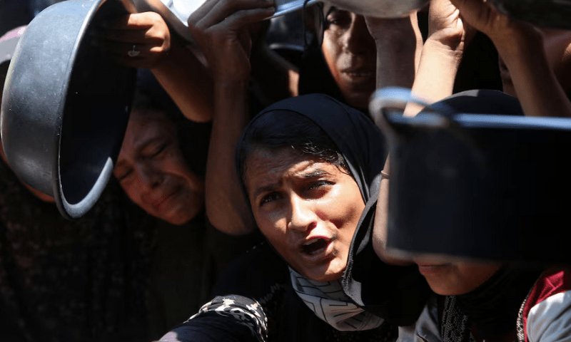 Palestinians wait to receive food from a charity kitchen, amid a hunger crisis, in Khan Younis, southern Gaza Strip, on August 4, 2025. Reuters
