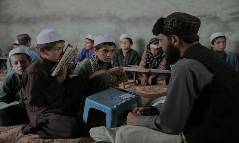  کابل، افغانستان کے مضافات میں عبداللہ ابن مسعود دینی اسکول میں مذہبی علوم کا ایک استاد افغان لڑکوں کو قرآن کی تعلیم دے رہا ہے۔ (تصویر: بشکریہ اے پی) 