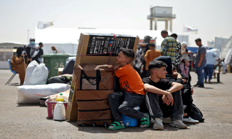 An Afghan family rests with their belongings at a camp for returning migrants near Islam Qala border crossing in Herat province, Afghanistan. – Reuters