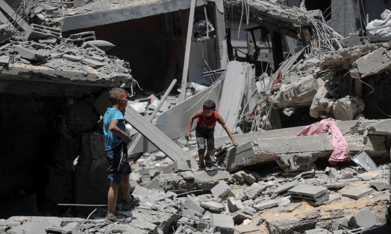Palestinian boys inspect the site of a morning Israeli strike on a house, in Gaza City, on August 8, 2025. Reuters