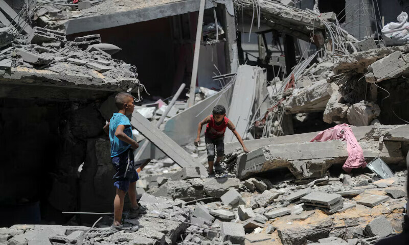 Palestinian boys inspect the site of an Israeli strike on a house in Gaza City. – Reuters