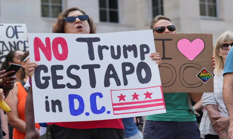 A demonstrator holds a sign during a protest near the White House in Washington DC. – Reuters