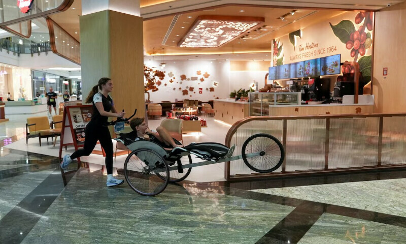 A participant pushes a disabled boy during the Dubai Mallathon in City Centre Mirdif Mall, in Dubai, United Arab Emirates, August 9, 2025. REUTERS