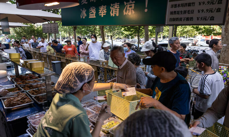 People queue at stalls selling food next to Beiyuan Grand Hotel in Beijing, China. – Reuters