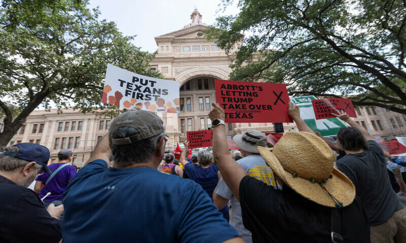 Protesters raise signs during the Fight the Trump Takeover rally in Austin, Texas, US. – Reuters