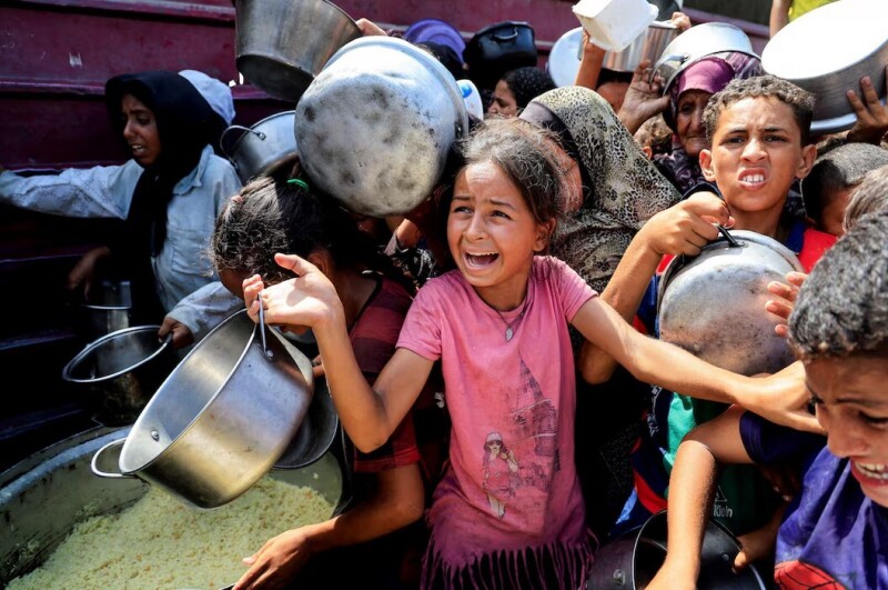 Palestinians wait to receive food from a charity kitchen, in Khan Younis, southern Gaza Strip, August 21, 2025. REUTERS/Hatem Khaled/File Photo