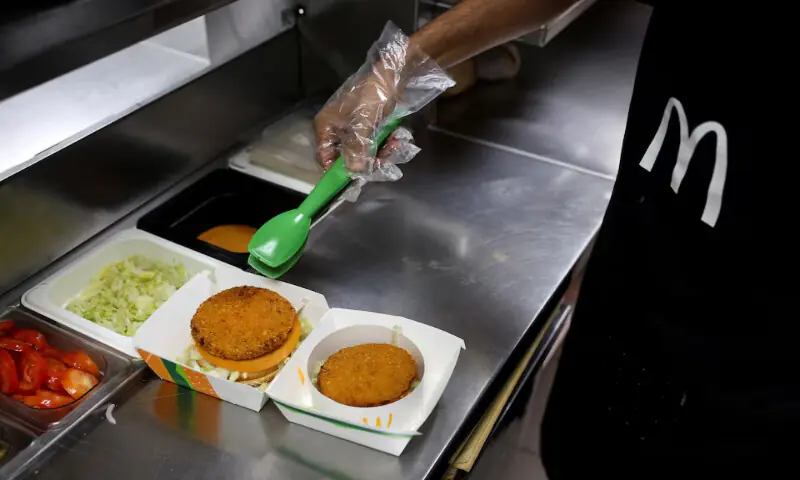 An employee prepares a vegetarian burger with an added protein slice at a restaurant in Mumbai, India. – Reuters