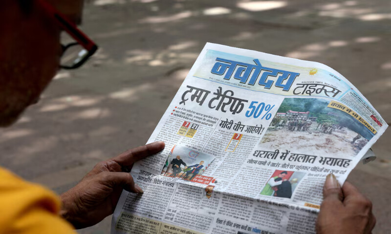 A man reads a newspaper with reports on US tariffs in New Delhi, India, on Wednesday. – Reuters