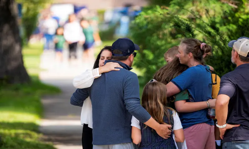 Families and loved ones reunite outside the police barricades after a shooting at Annunciation Church in Minneapolis, Minnesota. – Reuters