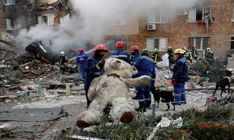 A rescuer holds a soft toy at the site of an apartment building which was hit by Russian missile and drone strikes in Kyiv, Ukraine, on Thursday. – Reuters