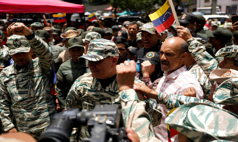 Venezuelan government supporters react to the arrival of Venezuela’s Defence Minister Vladimir Padrino Lopez following Venezuelan President Nicolas Maduro’s call for a nationwide recruitment drive amid rising tensions with the United States over the deployment of US warships in the Southern Caribbean and nearby waters. – Reuters