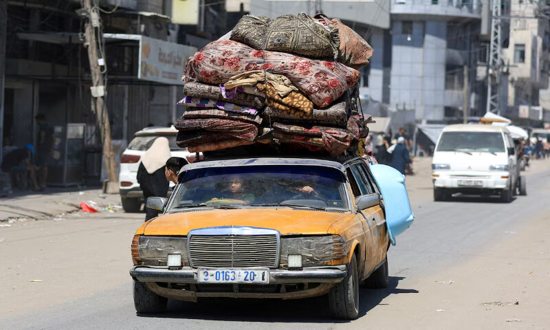 Displaced Palestinians ride in a vehicle loaded with belongings as they flee from one area to another within Gaza City. – Reuters