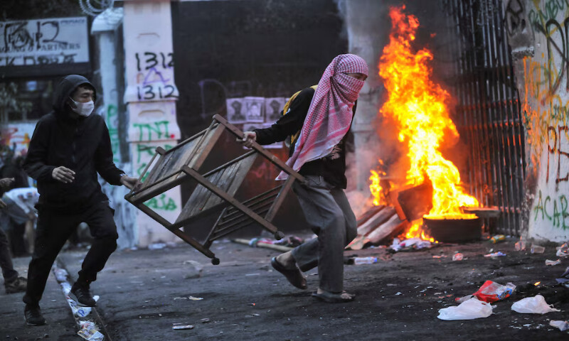 Protesters carry items to be burned outside the regional parliament building during a protest against the government’s spending priorities in Bandung, West Java province, Indonesia. – Reuters