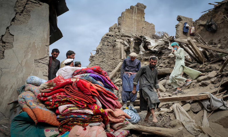 Afghan men walk on the rubble of a house damaged in the deadly earthquake in Mazar Dara, Kunar province, Afghanistan. – Reuters