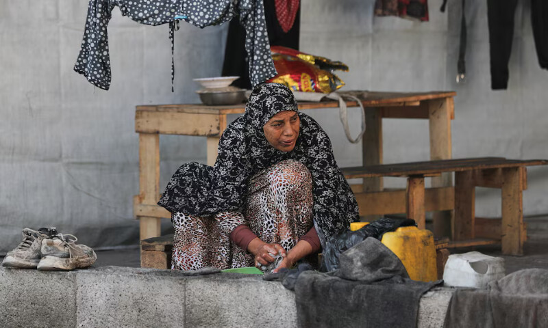 A Palestinian woman displaced by the Israeli military offensive takes shelter in a tent camp in Gaza City. – Reuters