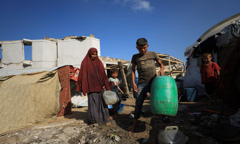 Palestinians displaced by the Israeli military offensive carry water in Gaza City. – Reuters