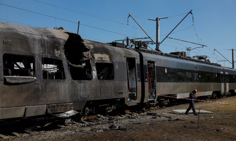 An engineer walks next to a Ukrainian train, which was hit by a Russian drone strike in Kyiv, Ukraine. – Reuters