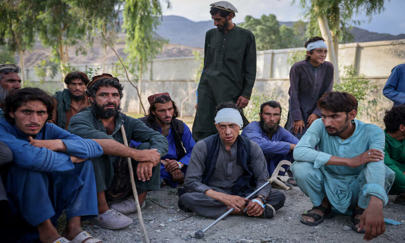 Victims of a deadly magnitude-6 earthquake wait outside a mobile clinic set up inside a school in Nurgal district, Kunar province, Afghanistan. – Reuters
