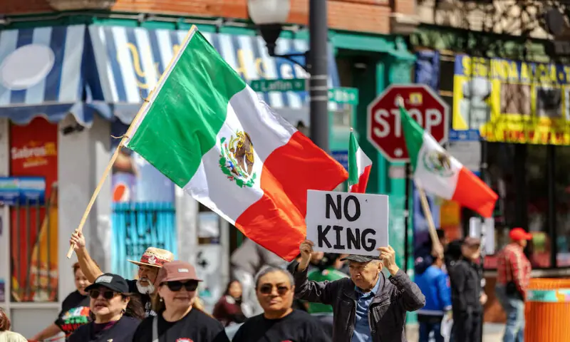 Parade participants fly Mexican flags and hold an anti-Trump sign as Chicago’s Mexican community proceeds with a Mexican Independence Day parade after US President Donald Trump ordered increased federal law enforcement presence in Chicago, Illinois. – Reuters