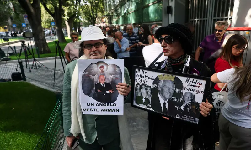 People holding placards queue outside the Armani/Teatro to pay tribute as designer Giorgio Armani lies in state, following his death, in Milan, Italy.  – Reuters