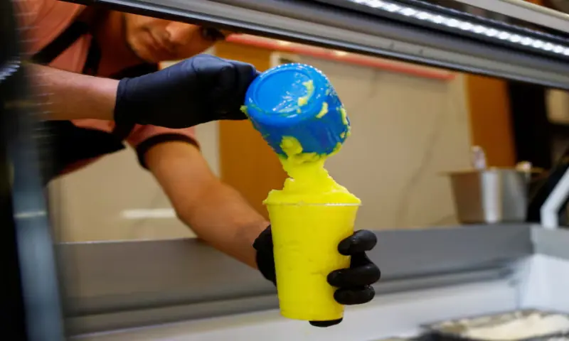 A worker fills a cup of ‘Barrad’, a traditional Palestinian slushy drink with citrus flavours, at a newly opened branch of an ice cream shop in Ajman, on August 19, 2025. Reuters