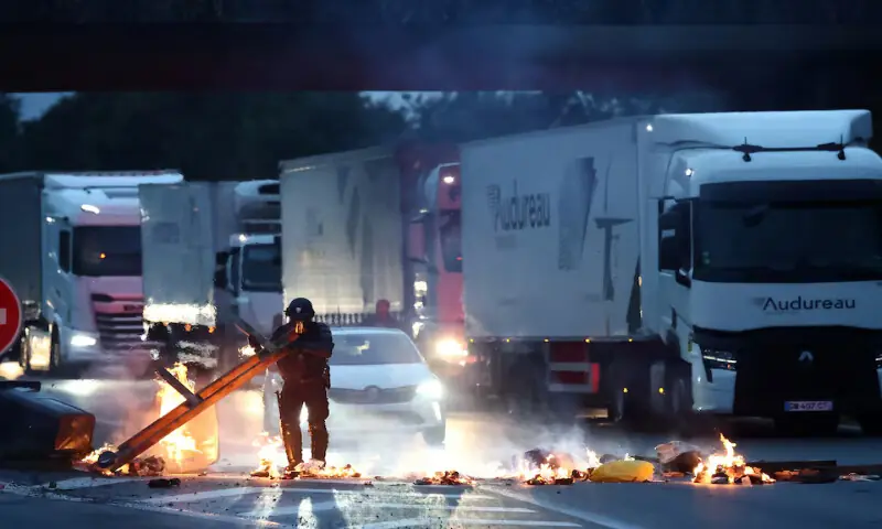 A police officer removes an object placed by demonstrators to block traffic on the ring road in Nantes, France, on Wednesday. – Reuters
