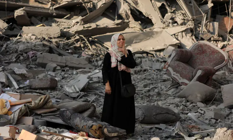 A Palestinian woman inspects the damage at the site of Israeli strikes that destroyed Al Jundi Al Majhoul residential tower in Gaza City. – Reuters