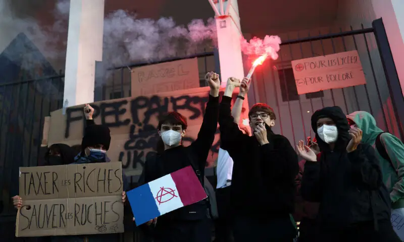 French masked school students raise their fists as they block the entrance of the Lycee Maurice Ravel high school in Paris on Thursday. – Reuters