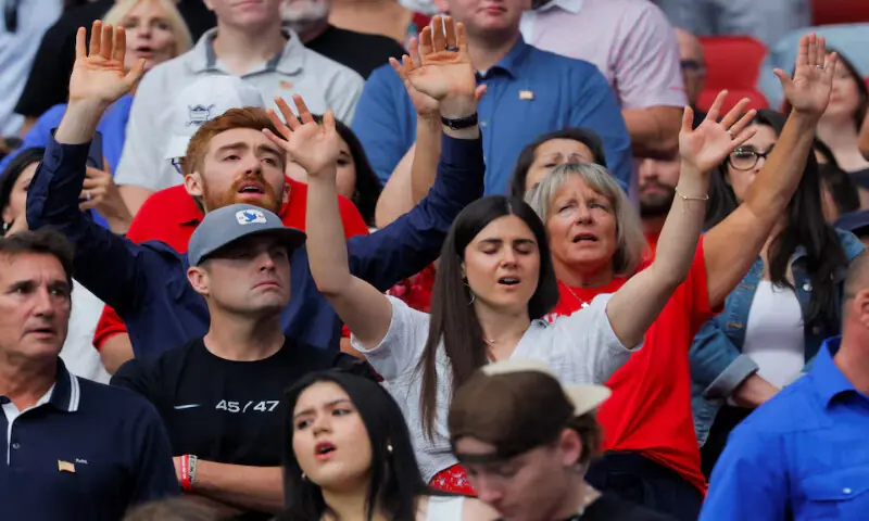 People gesture during a memorial service for Charlie Kirk at State Farm Stadium in Glendale, Arizona, US. – Reuters