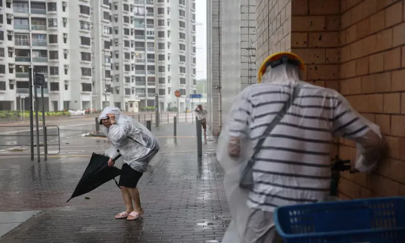 People brave strong winds as Super Typhoon Ragasa approaches in Hong Kong, China, on Wednesday. – Reuters