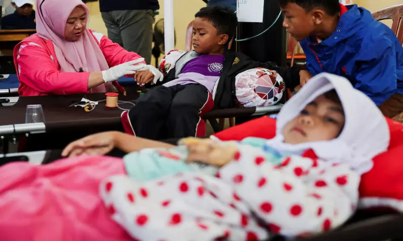 Students receive treatments for food poisoning at a makeshift clinic inside a district’s hall in Bandung, West Java province, Indonesia, on Thursday. – Reuters