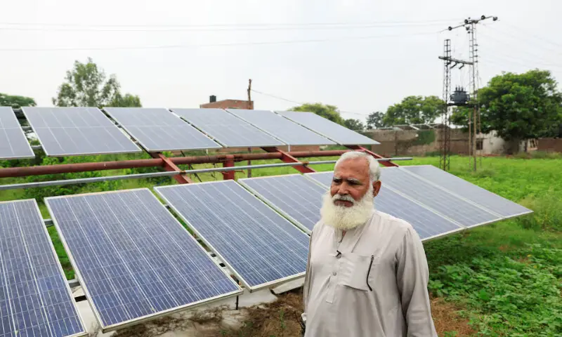 Mohammad Naseem, a farmer, stands beside his solar panels amid a rice field in Muridke, Sheikhupura District in Punjab. – Reuters