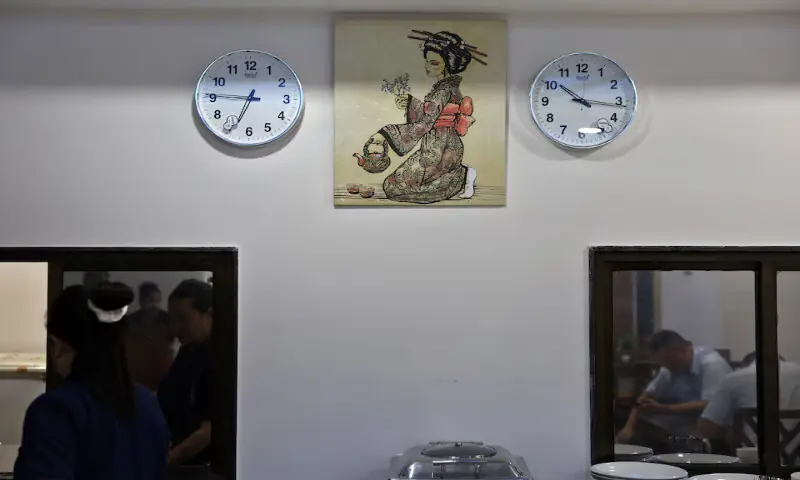 Two wall clocks displaying Indian and Japanese time zones hang along with a Japanese painting, inside the Mizuki Ryokan hotel in Vithalapur village, Gujarat. – Reuters