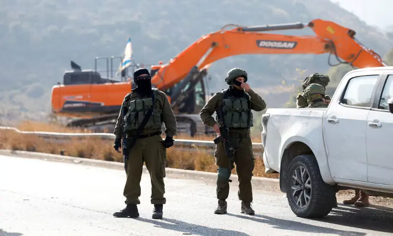 Israeli soldiers stand guard during the construction of Israeli bypass road infrastructure near Ramallah in the Israeli-occupied West Bank. – Reuters