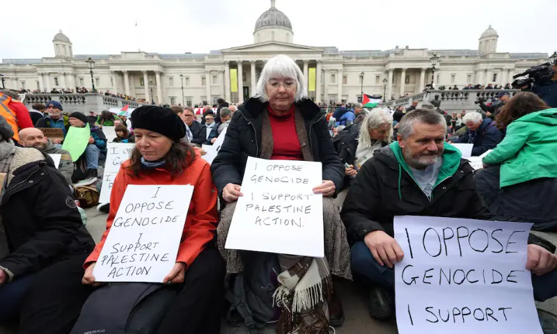 Protesters hold signs during a mass demonstration against the British government’s ban on Palestine Action at Trafalgar Square in London. – Reuters