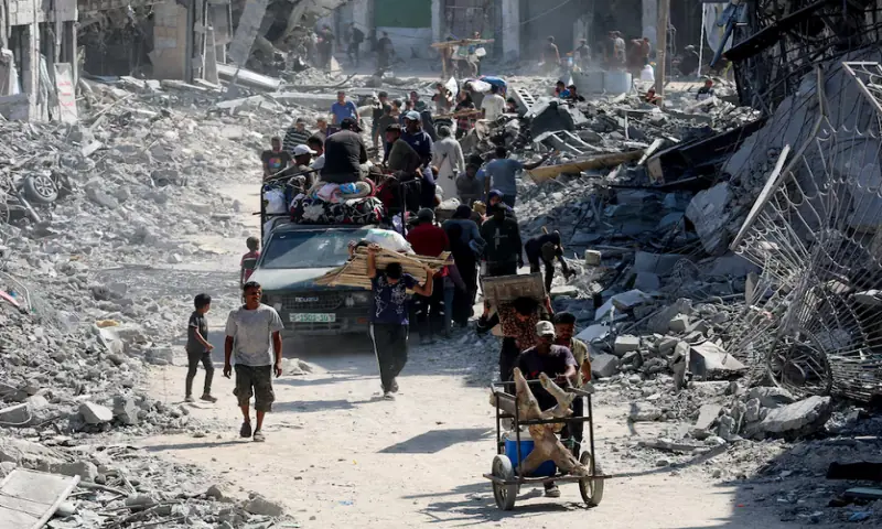 Palestinians walk past the rubble following Israeli forces’ withdrawal from the area, after Israel and Hamas agreed on the Gaza ceasefire, in Khan Younis, in the southern Gaza Strip, on October 10, 2025. Reuters
