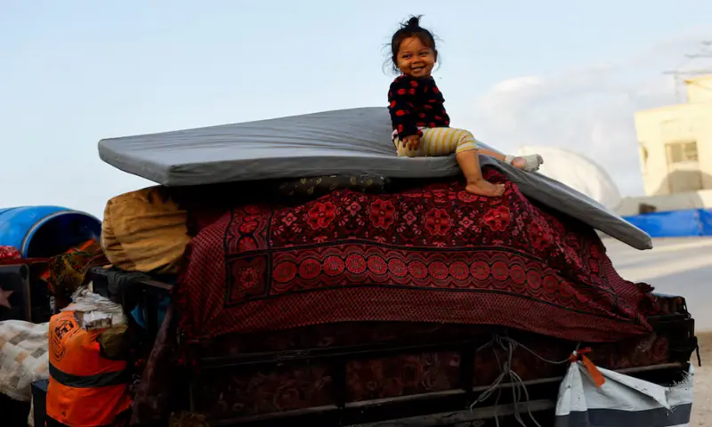 A child sits atop belongings on a vehicle as Palestinians, who were displaced to the southern part of Gaza at Israel’s order during the war, attempt to return to the north, after Israel’s government ratified a ceasefire with Hamas, in the central Gaza Strip on October 10, 2025. Reuters