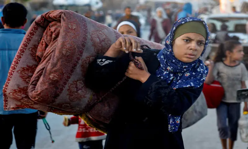 A Palestinian woman, who was displaced to the southern part of Gaza, makes her way along a road to return to the north in the central Gaza Strip. – Reuters