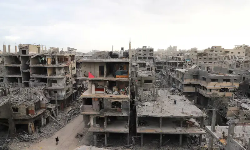 A Palestinian walks near damaged buildings in the aftermath of Israeli military strikes at Shati refugee camp in Gaza City on Sunday. – Reuters