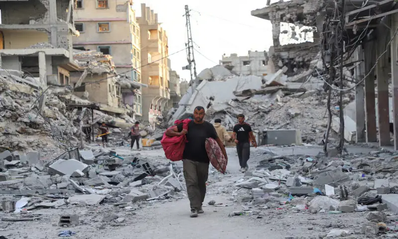 Palestinians walk near rubble in the aftermath of Israeli attacks at Shati refugee camp in Gaza City on Sunday. – Reuters
