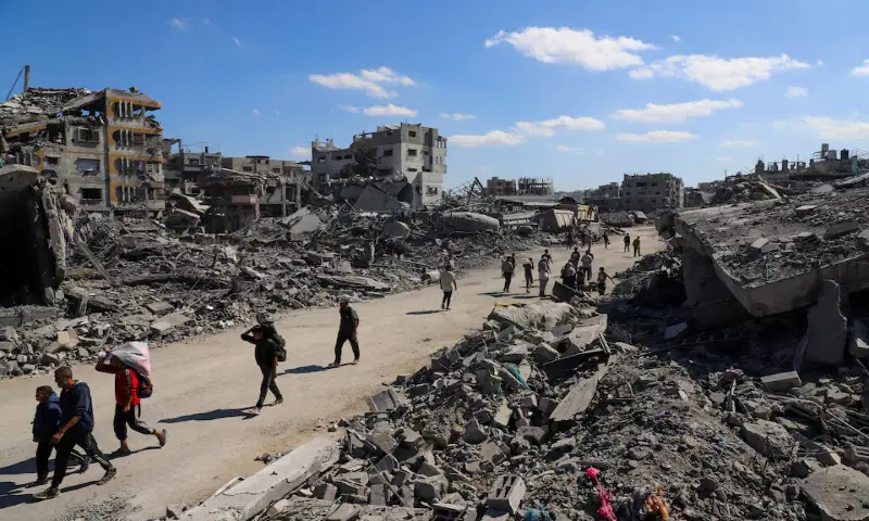 Palestinians walk past the rubble of destroyed buildings in Gaza City on Tuesday. – Reuters